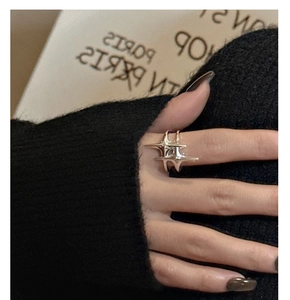 Détail d'une bague étoile en argent minimaliste portée au doigt au style moderne