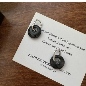 Detailed close-up of S925 silver U-shape earrings with dark natural stone pendants