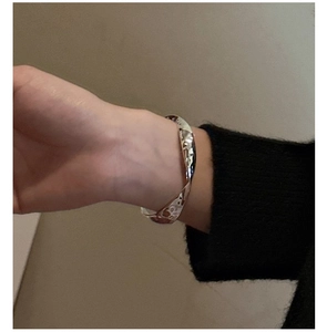 Détail de la texture martelée et du design torsadé de ce bracelet jonc en argent chic