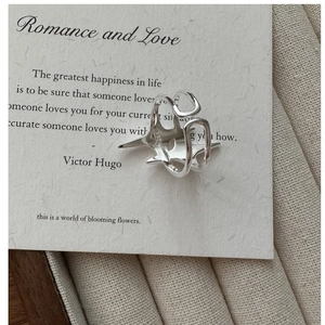 Détail d'une bague étoile en argent S925 posée sur une carte avec texte romantique