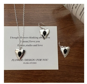 Detailed view of S925 silver heart necklace and earrings with black agate inlay set