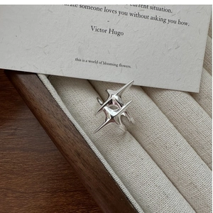 Détail de la bague étoile en argent sur un plateau de bijoux en velours avec cadre en bois