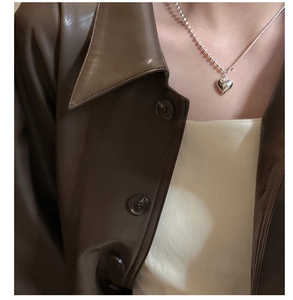 Detail of S925 silver heart necklace with asymmetric ball and snake chain on model