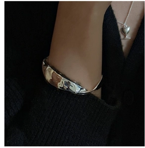 Détail du bracelet jonc en argent S925 au design ondulé et texture de métal liquide