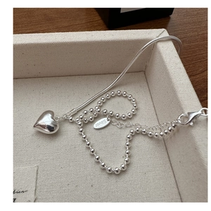 Detailed macro of S925 silver heart necklace with asymmetric snake and bead chain link