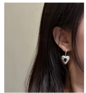 Close-up of S925 silver heart earring with black agate drop on a female model