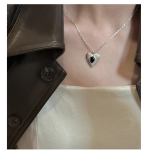 Close-up of heart-shaped S925 silver necklace with black agate stone inlay on a model