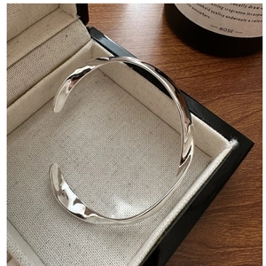 Détail du bracelet en argent S925 au design de vague et texture métallique liquide
