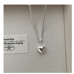 Detailed macro view of S925 sterling silver heart necklace with asymmetric double chains