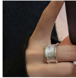 Vue détaillée d'une bague large en argent S925 avec texture martelée portée à la main