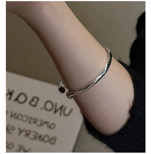 Close-up of minimalist silver cuff bracelet with unique molten lava texture on wrist