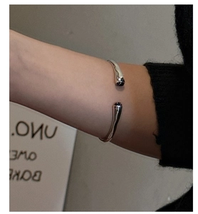 Macro detail of silver open bracelet with liquid metal texture and black onyx stones