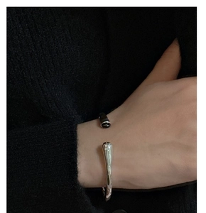 Close-up of minimalist sterling silver open bangle featuring a sleek streamlined design