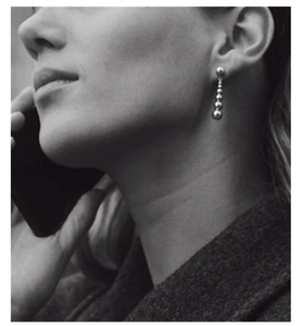 Detailed view of sterling silver gradient bead drop earrings on a professional model