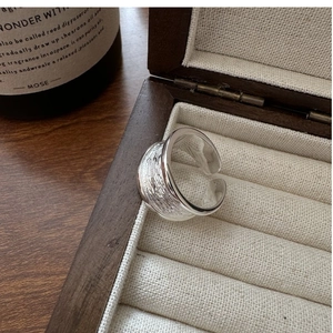 Détail d'une bague ouverte large en argent S925 avec texture dans son écrin de luxe