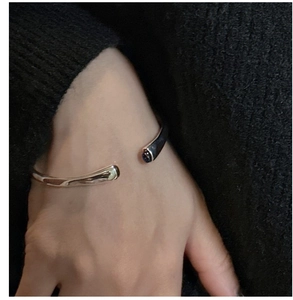 Close-up of minimalist 925 silver open bangle with black agate ends on a wrist