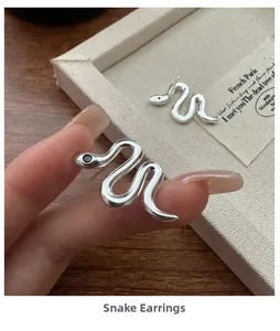 Close-up of S925 sterling silver snake earrings with polished finish and black stones