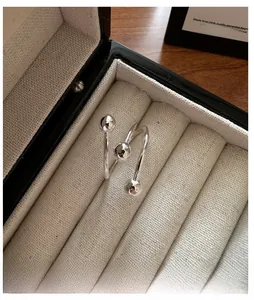 Vue détaillée d'une bague spirale en argent S925 avec billes polies dans son écrin