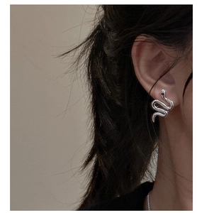 Macro detail of minimalist S925 sterling silver snake stud earring on model's ear