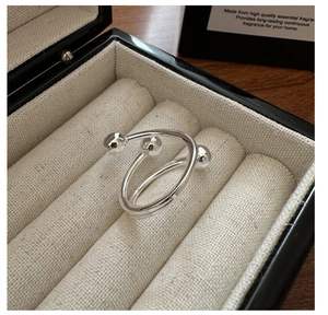 Détail d'une bague en argent S925 avec design spirale à trois billes dans son écrin