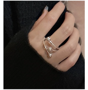 Détail de la bague spirale triple en argent S925 avec perles polies sur tissu noir