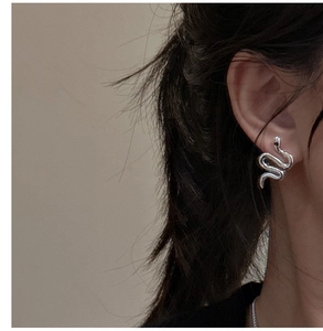 Detailed close-up of S925 sterling silver snake earrings worn on a person ear