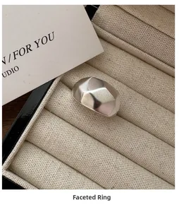 Detail shot of a minimalist hammered silver ring inside a beige fabric jewelry box