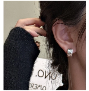 Close-up of S925 sterling silver hoop earring with hammered texture on female model