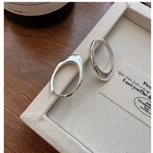 Detailed close-up of polished S925 sterling silver oval hoop earrings on display