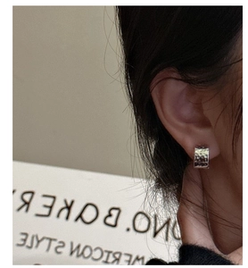 Macro shot of S925 sterling silver hoop earrings with hand-hammered texture on ear