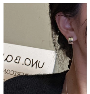 Close-up of S925 sterling silver hoop earrings with irregular hammered texture on ear