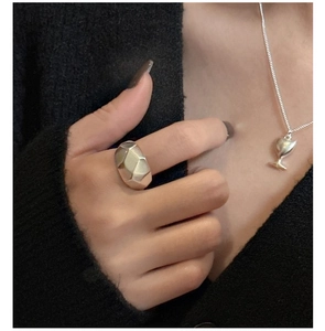 Detail showing matte silver geometric ring and matching dainty trophy pendant necklace
