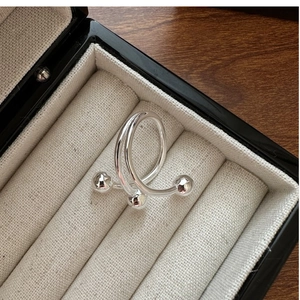 Détail d'une bague en argent sterling S925 avec design spirale double et trois perles