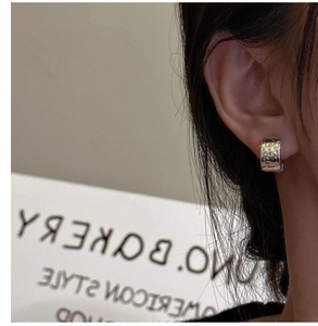 Detailed close-up of S925 sterling silver hoop earrings with a hammered texture on model