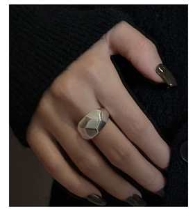Close-up of minimalist S925 sterling silver wide ring with geometric diamond-cut matte finish