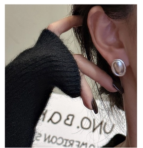 Vue détaillée de boucles d'oreilles ovales en argent S925 mat portées par un mannequin