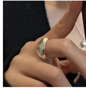 Macro side view of silver S925 sterling silver geometric faceted ring on model's finger