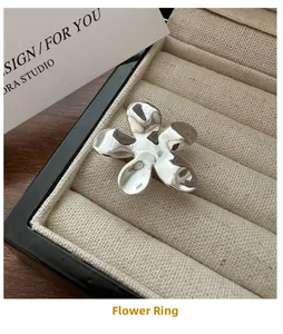 Gros plan d'une bague fleur en argent placée dans un écrin à bijoux en velours beige