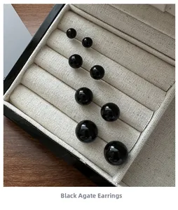 Macro shot of four sizes of black agate stud earrings in a professional jewelry display