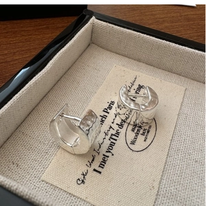 Macro detail of S925 sterling silver hoop earrings with irregular hammered texture finish