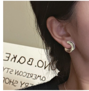 Close-up of chunky C-shaped S925 sterling silver hoop earrings with high-polish finish