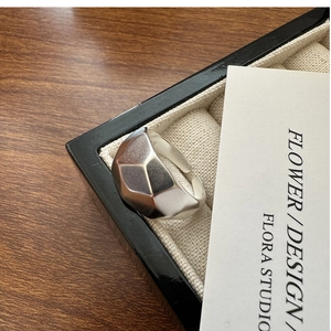 Macro detail of silver geometric matte ring featuring a multi-faceted minimalist design