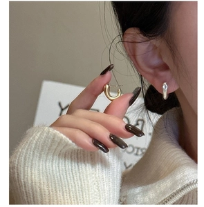 Gros plan de boucles d'oreilles clous en C minimalistes en argent S925 or et argent