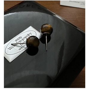 Macro view of S925 sterling silver tiger eye stud earrings with visible S925 hallmark