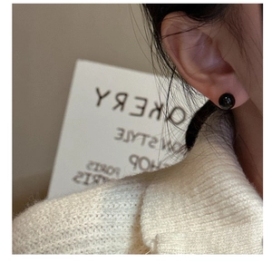 Minimalist S925 silver stud earrings with black onyx bead worn with white sweater