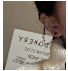 Macro side view of a minimalist S925 silver stud earring with a tiger eye stone sphere