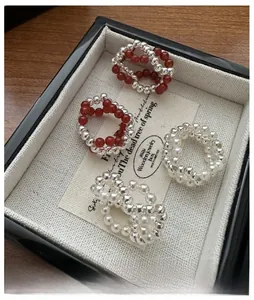 Detail of s925 silver beaded rings with red gemstones and pearls on jewelry tray