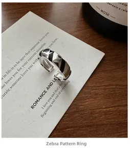Detailed close-up of S925 sterling silver ring with black zebra enamel stripes