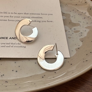 S925 sterling silver C-shaped hoop earrings with polished finish on decorative tray