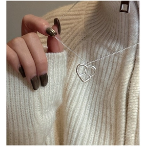 Gros plan détaillé du pendentif coeur évidé en argent S925 sur une fine chaîne maille